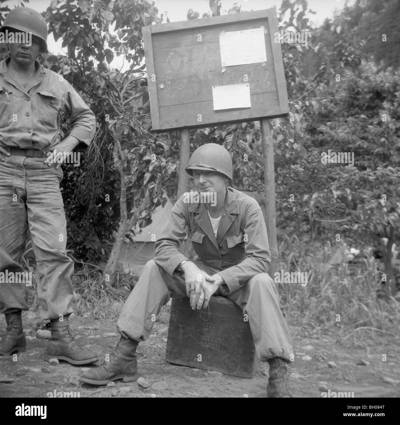 Two war weary members of the U.S. Army, Second Division relax at the unit's command post during the Korean War. Stock Photo