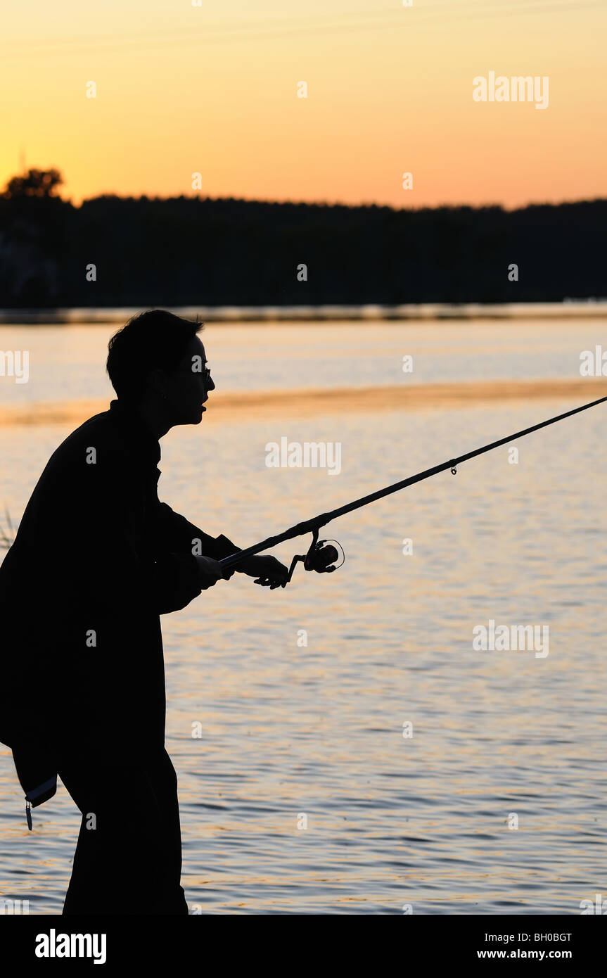 silhouette of alone fisherman Stock Photo