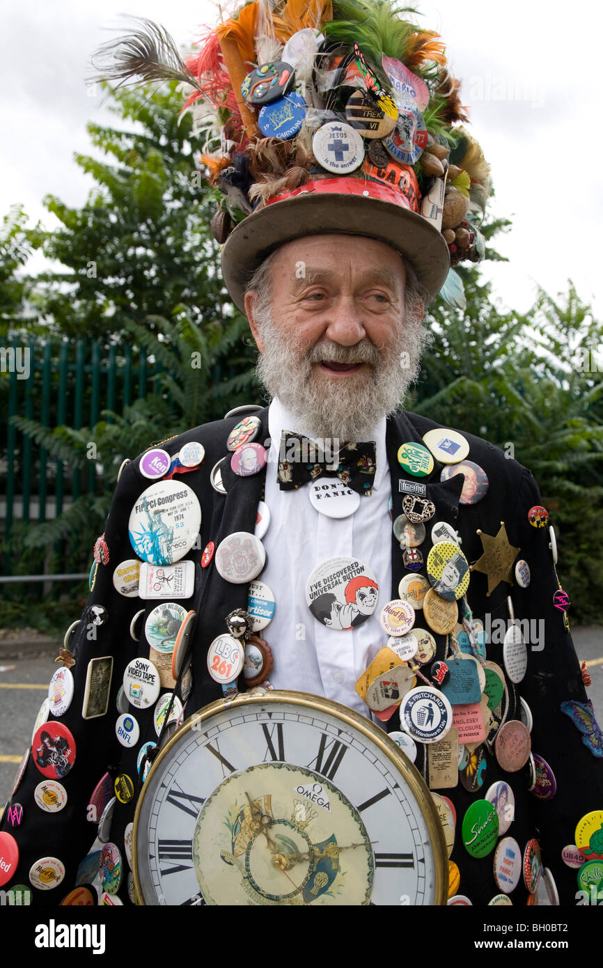Bearded old man in carnival costume. Lots of badges & top hat. Notting Hill Carnival, Notting Hill. London. England. UK. Stock Photo