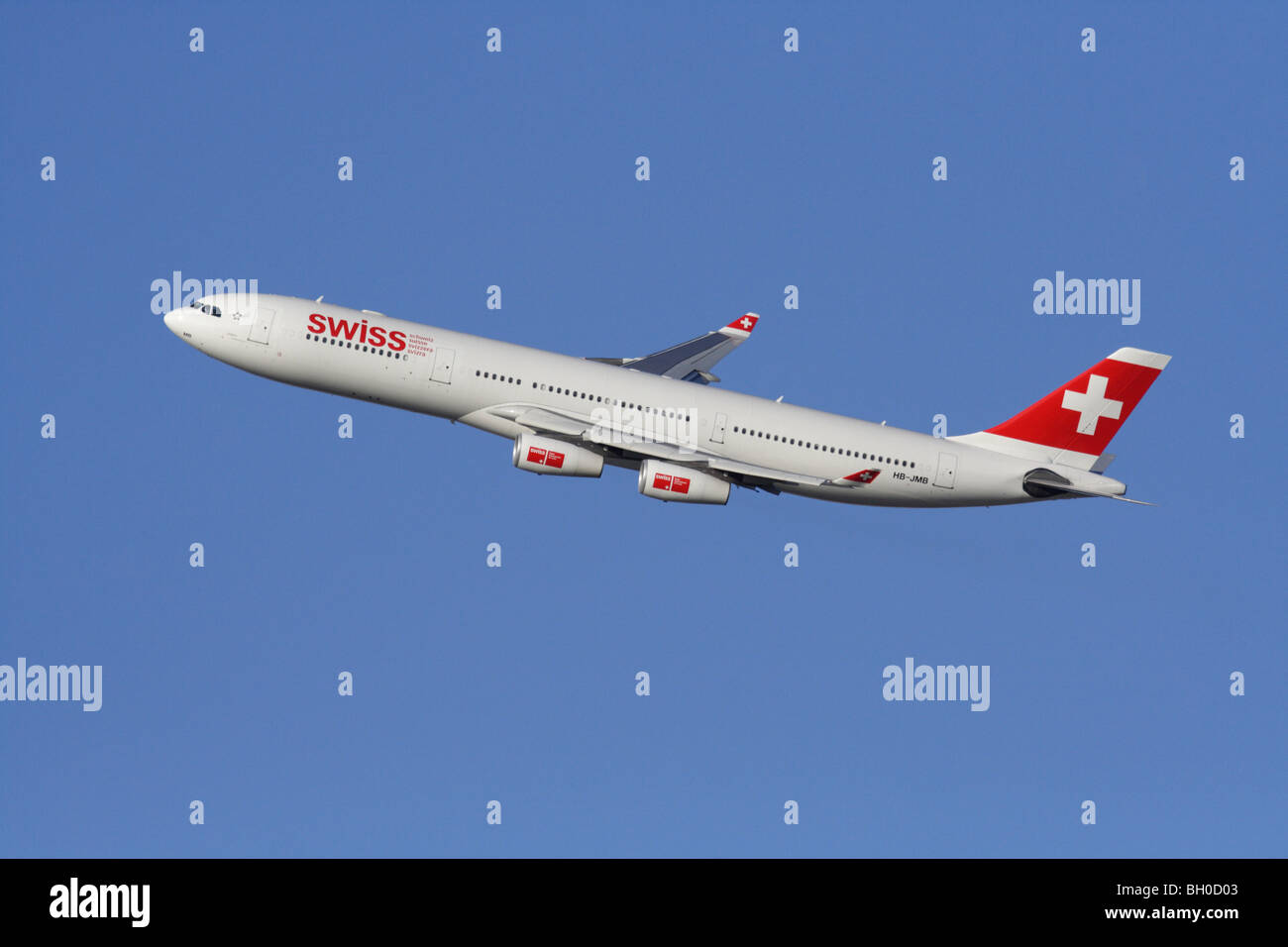 Air travel. Swiss International Air Lines Airbus A340-300 jet plane flying in the air against a clear blue sky Stock Photo