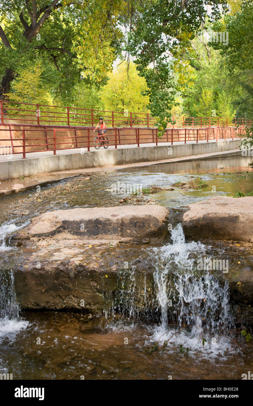 A visitor rides on a bike trail through downtown Moab, Utah. (model