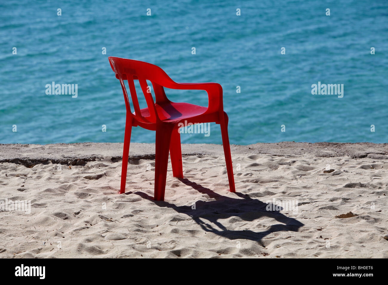 Red plastic chair blue water, Dominican Republic Stock Photo Alamy