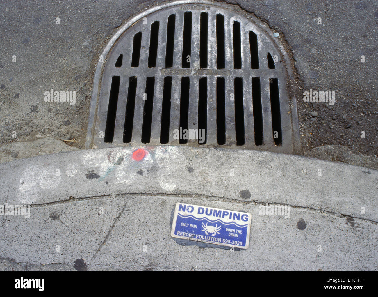 no dumping into storm drain, warning sign. Red spray paint mosquito abatement mark, San Francisco, California, USA Stock Photo