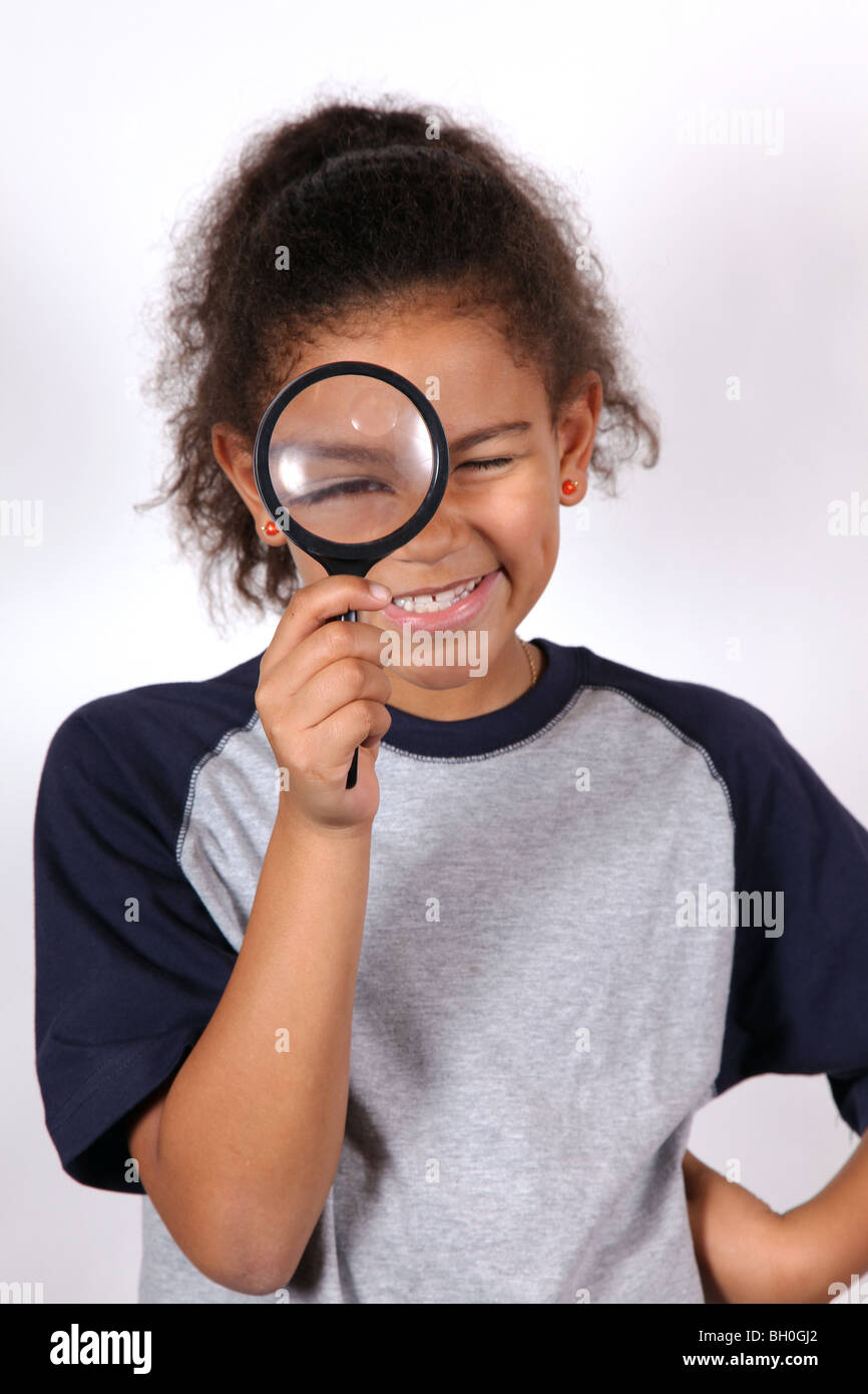 African-American girl looking through a magnifying glass Stock Photo