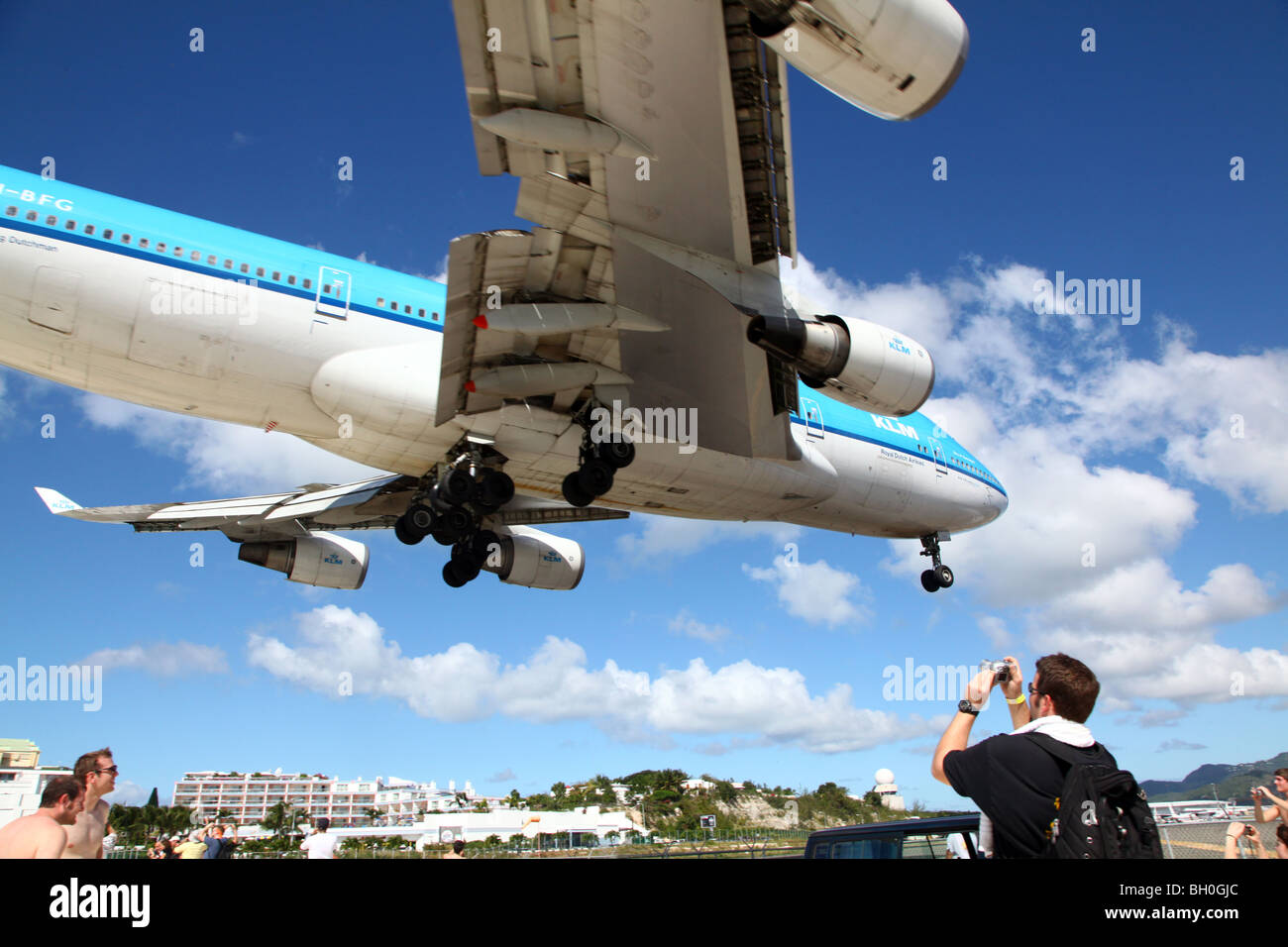 KLM 747 flying directly overhead of tourists at Maho Beach, St Maarten, Caribbean Stock Photo