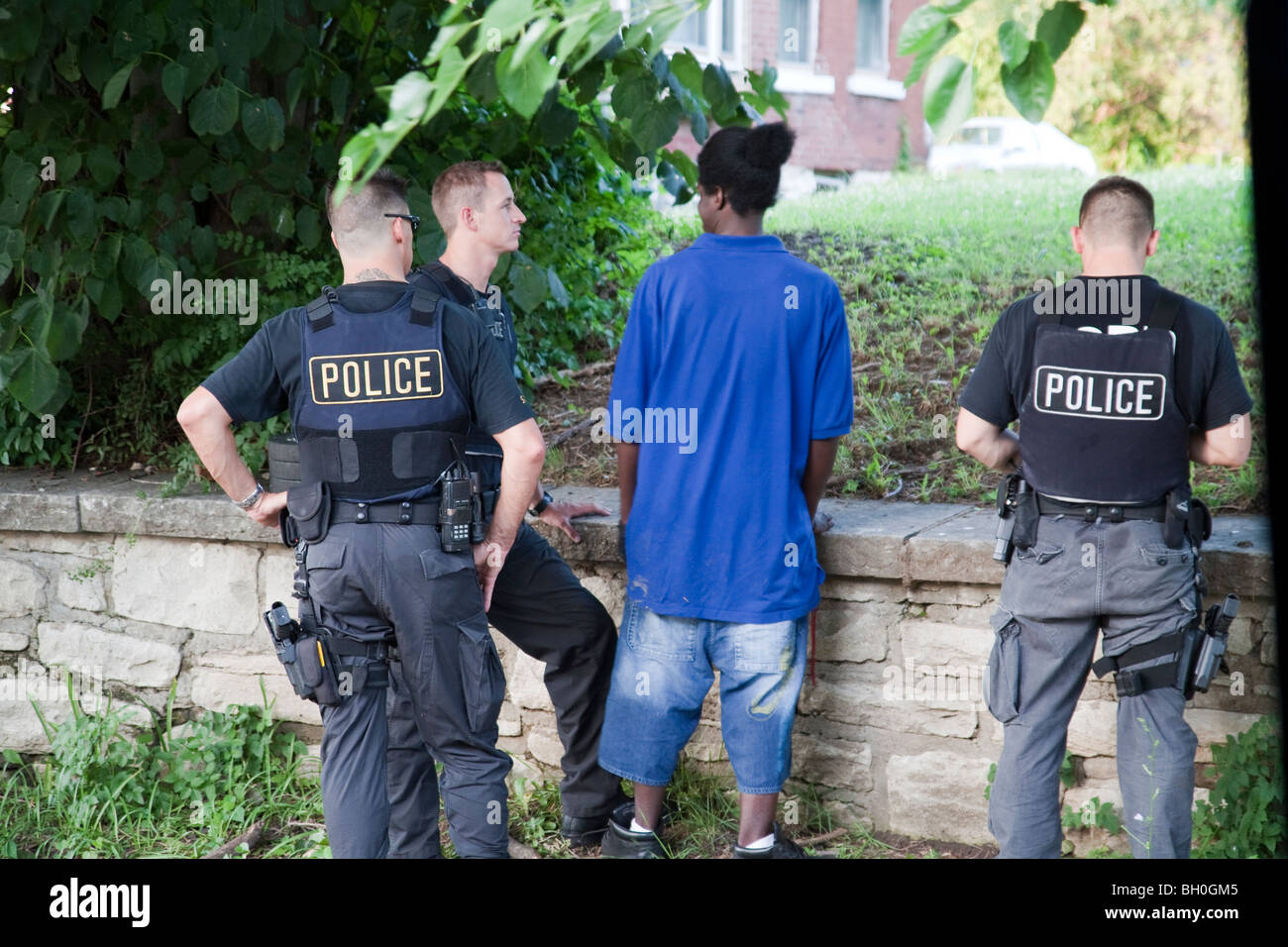 Police officers from tactical squad talking to suspect. Stock Photo