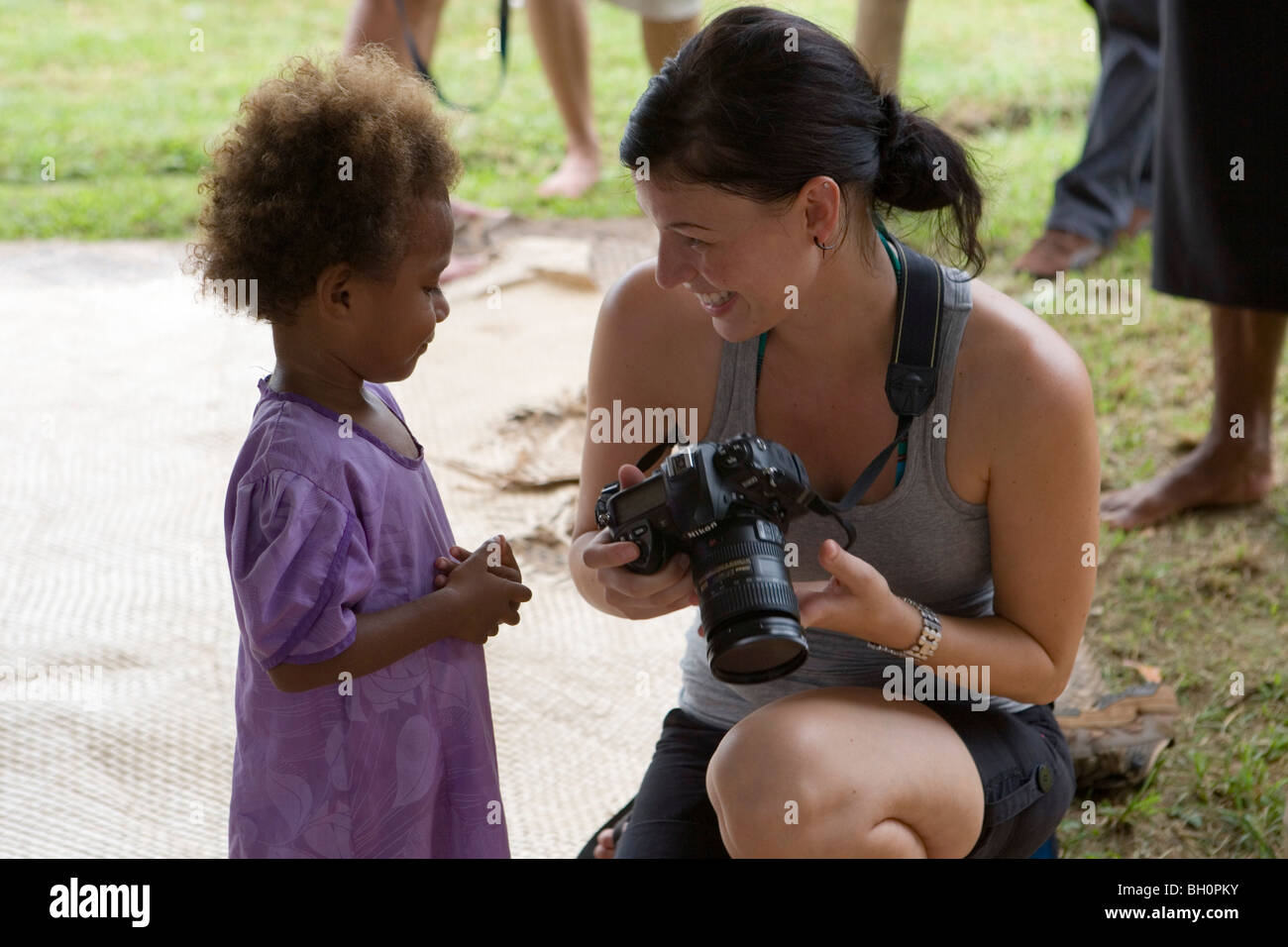 Young woman showing pictures on her camera to fijian child, Naidi, Vanua Levu, Fiji Islands, South Pacific, Oceania Stock Photo