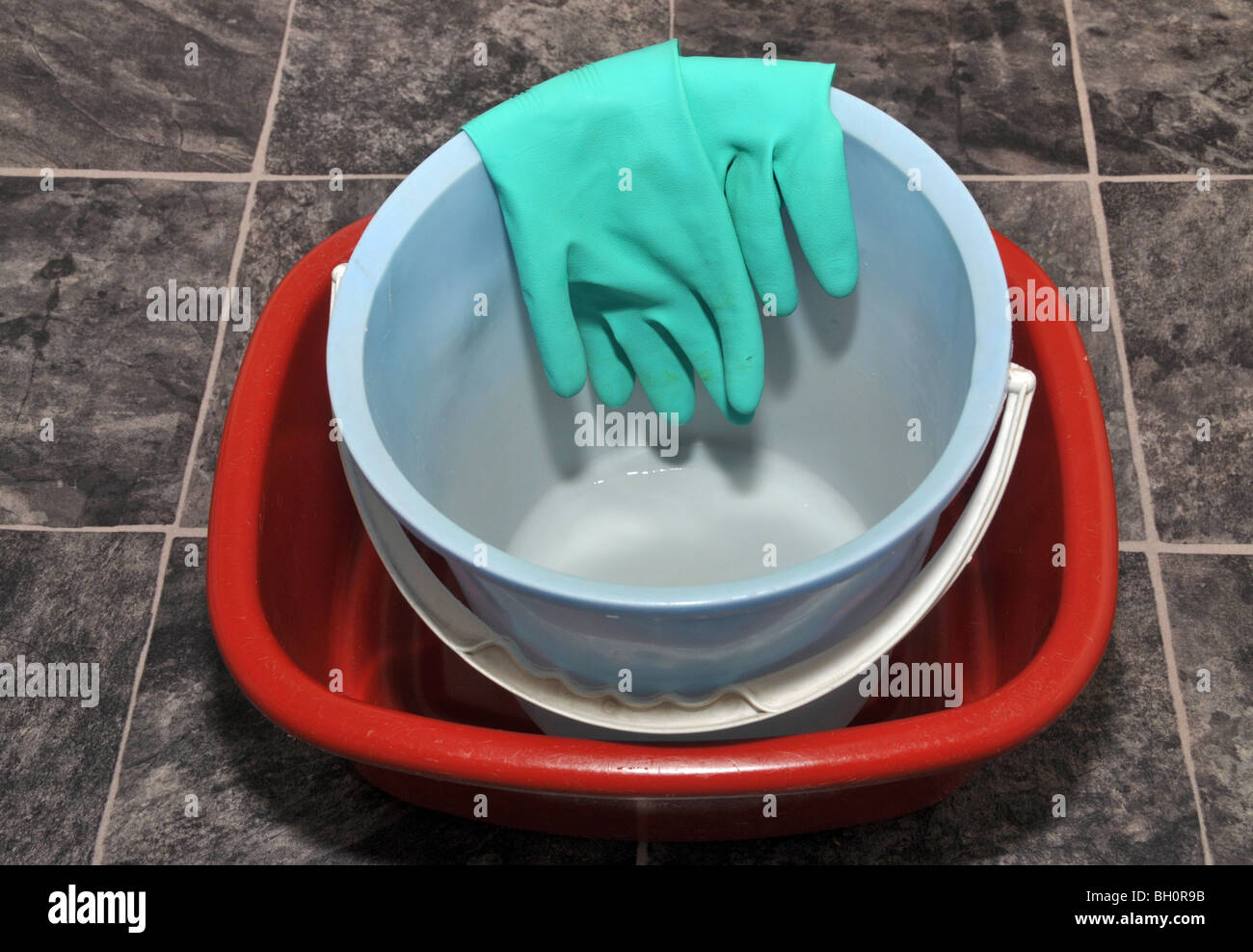 Plastic basin and washing pail with rubber gloves. Stock Photo