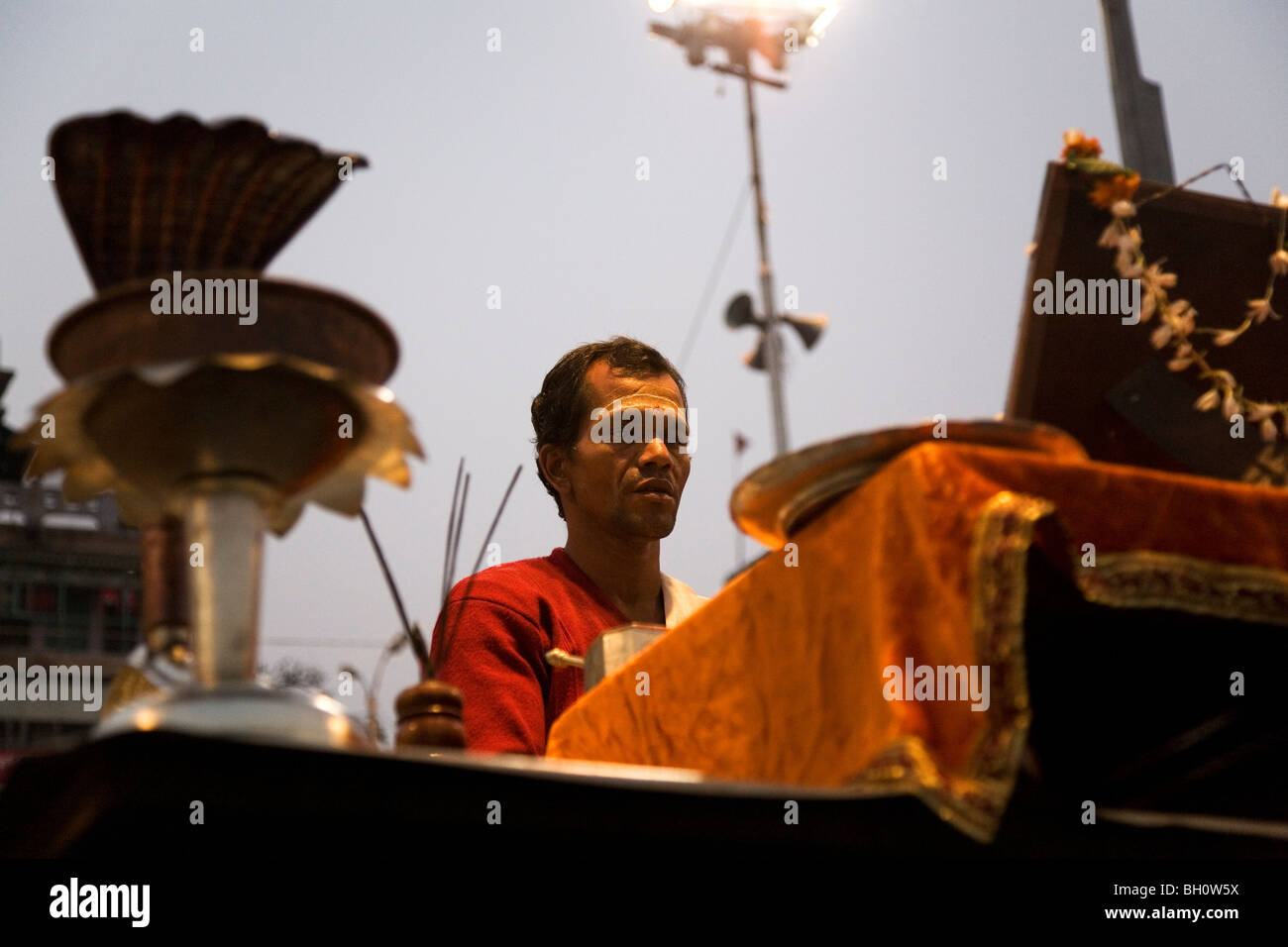 A Hindu priest conducts the daily Ganga Aarthi ritual by the banks of the River Ganga (Ganges) in the city of Varanasi, India. Stock Photo