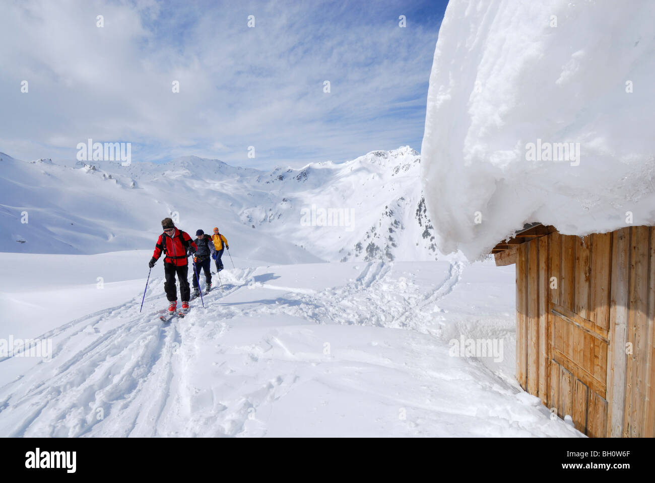 Backcountry skiers reaching snow-covered alpine hut, Marchkopf, Hochfuegen, Zillertal, Tyrol, Austria Stock Photo