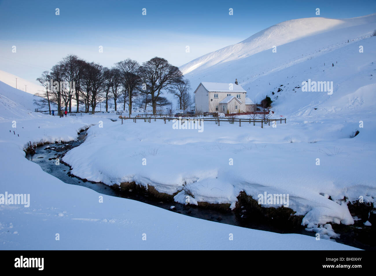 Farmhouse and stream in snowy Pentland hills, Lothian, Scotland Stock Photo
