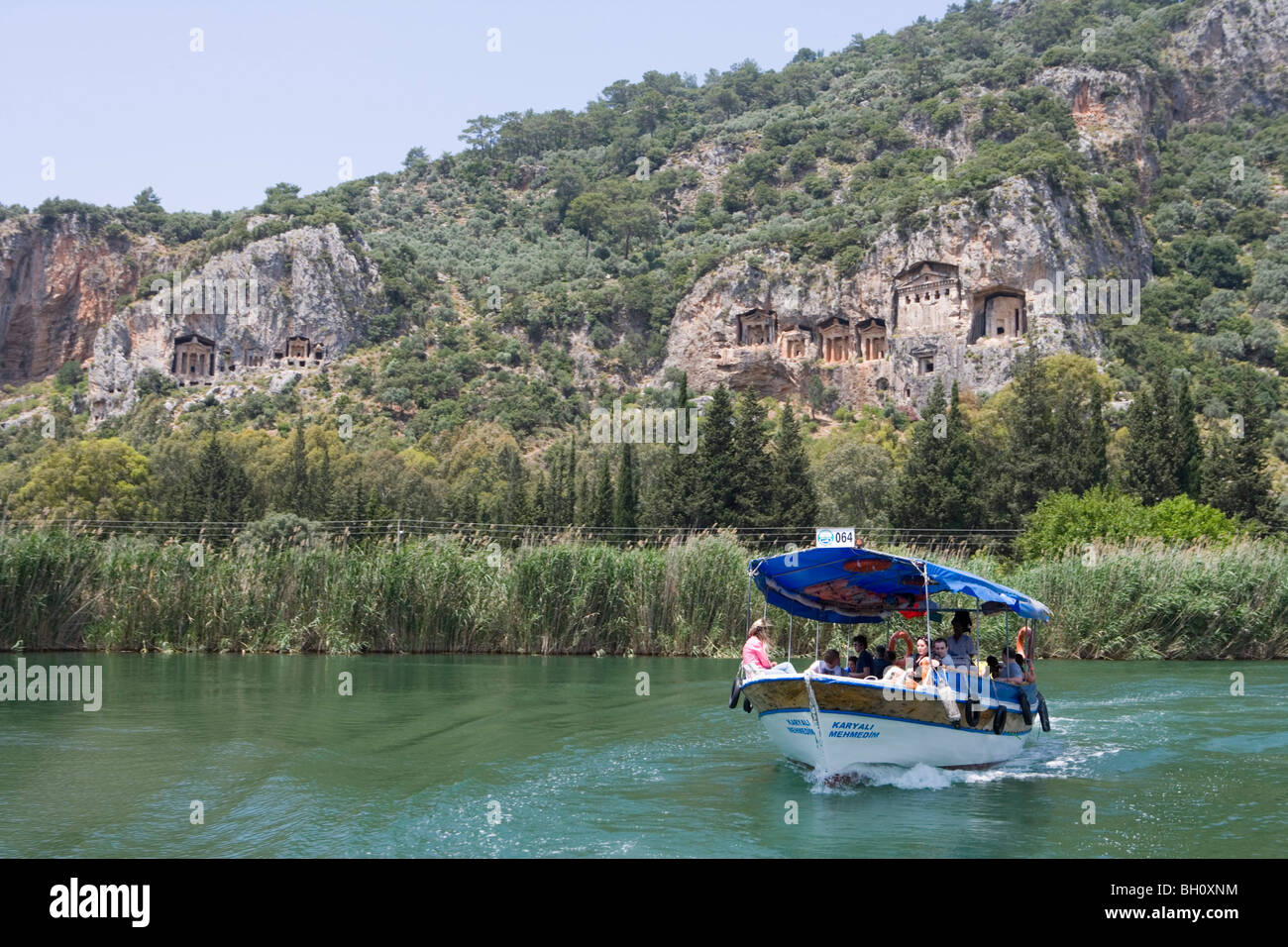 Excursion boat on the Dalyan river and Lycian Cliff Tombs, Dalyan River, Turkey, Europe Stock Photo