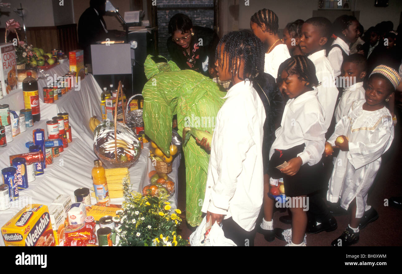 Black children bring harvest gifts for the church for distribution to the poor, London Stock Photo