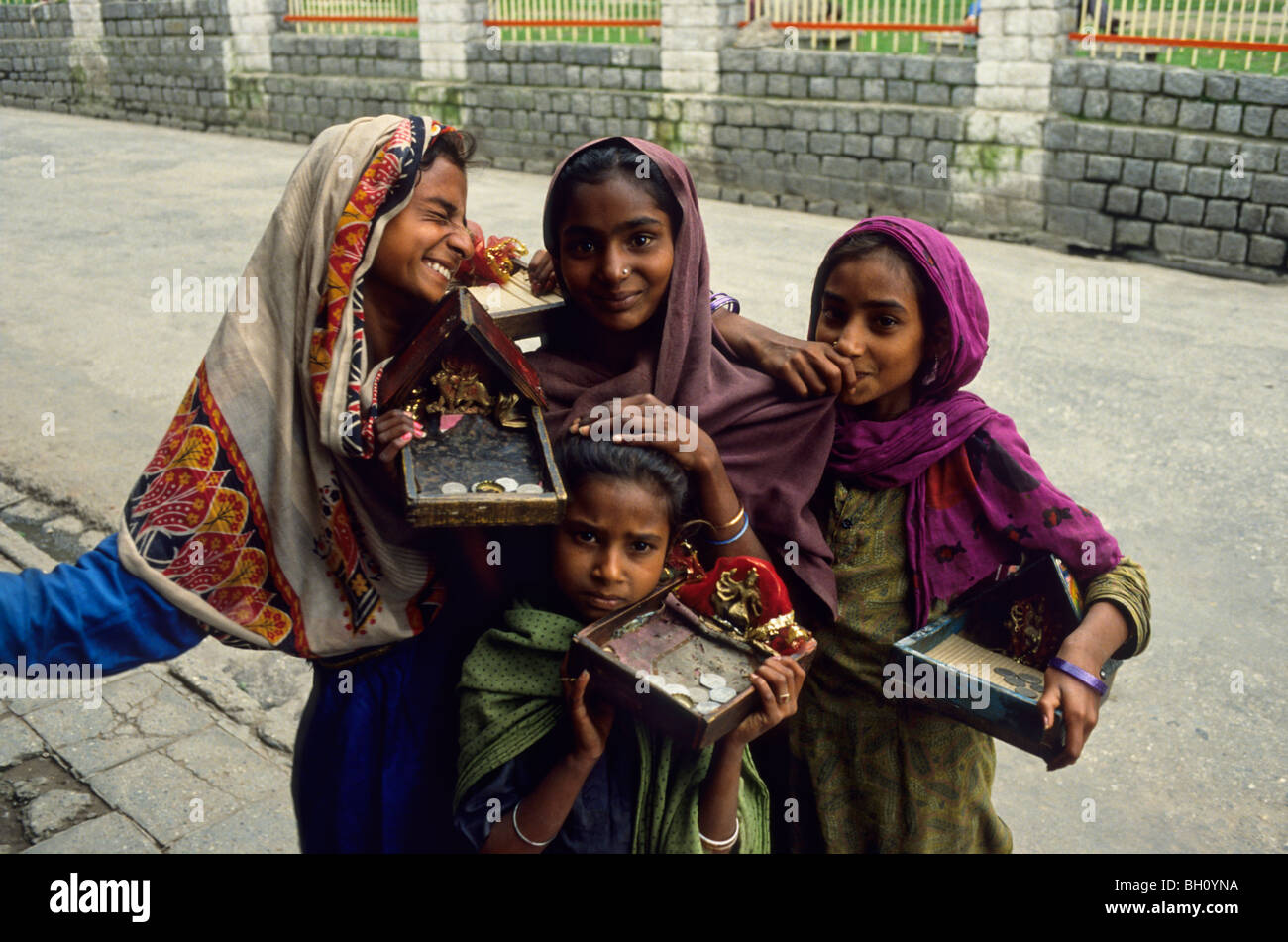Four young girls are begging in a street of New Delhi. Stock Photo