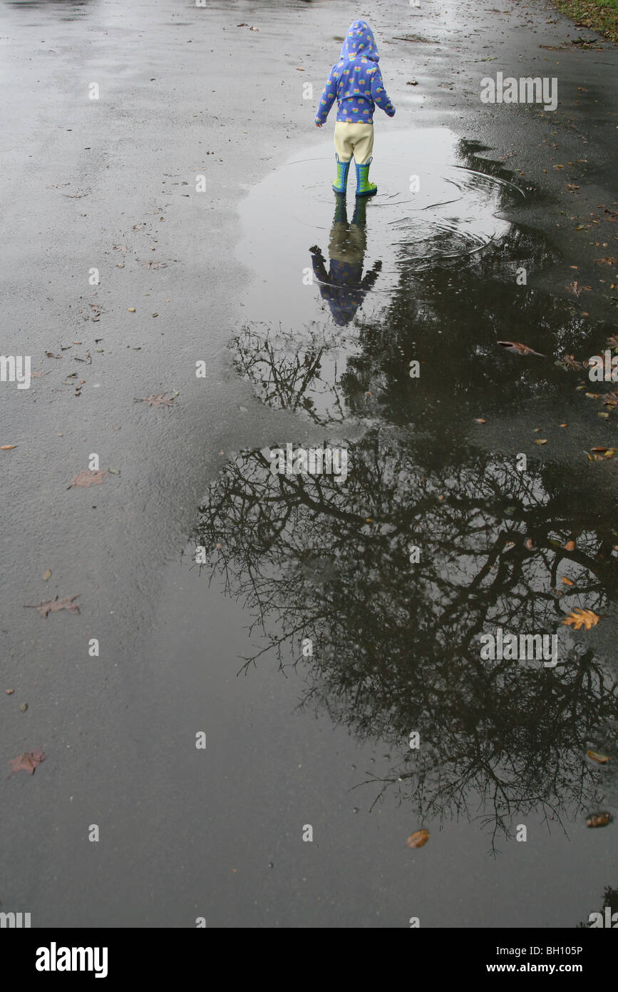 A young child walking in a puddle. Stock Photo
