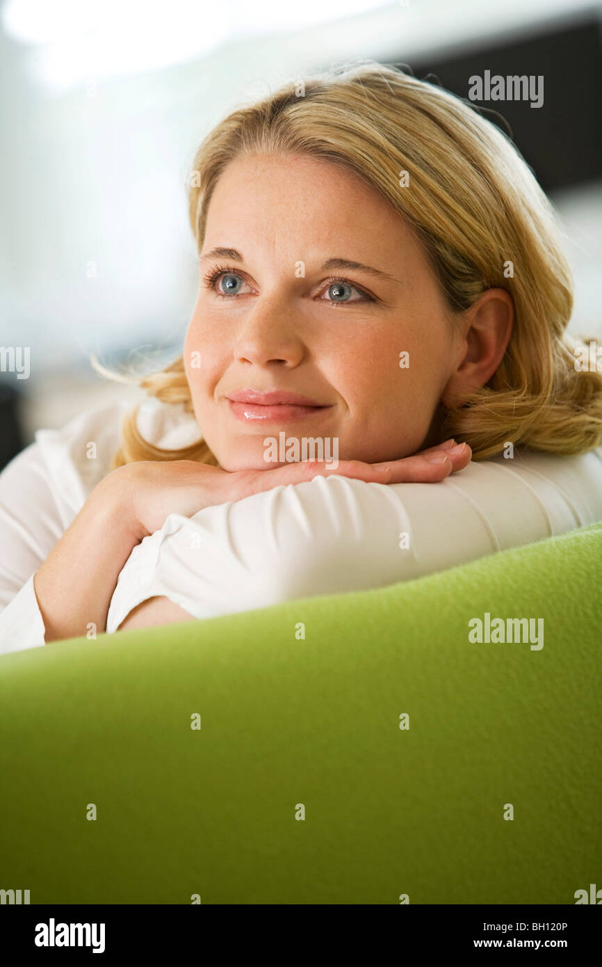 Woman lying happily on couch Stock Photo - Alamy
