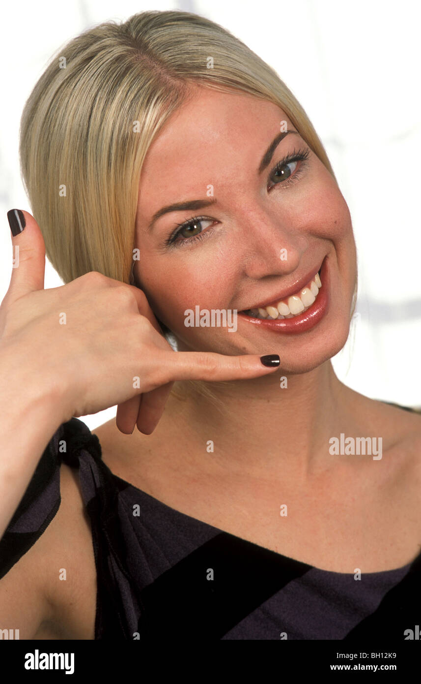 Young Woman Gesturing 'Call Me' Stock Photo