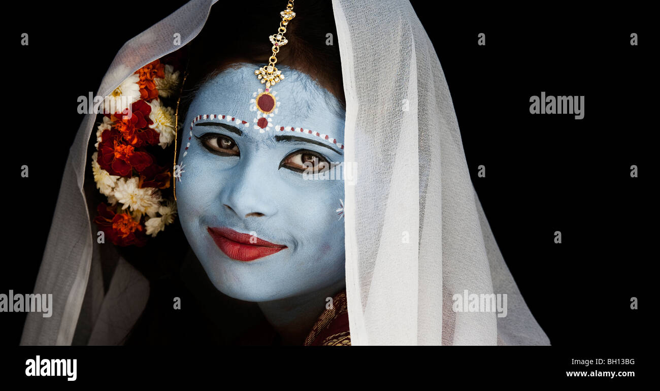 Indian girl face painted as the Hindu goddess Sita against a black