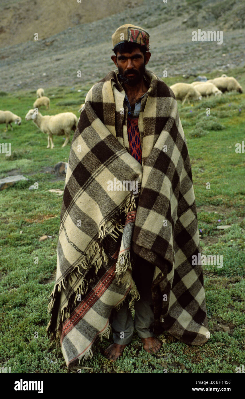 Shepherd in Northern India. He is barefooted and warms himself with a blanket. Stock Photo