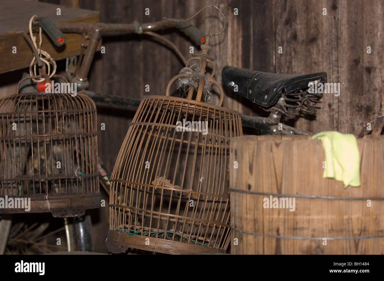 Dusty bicycle and birdcages stowed away in a shed .Jiangxi province, China. Stock Photo