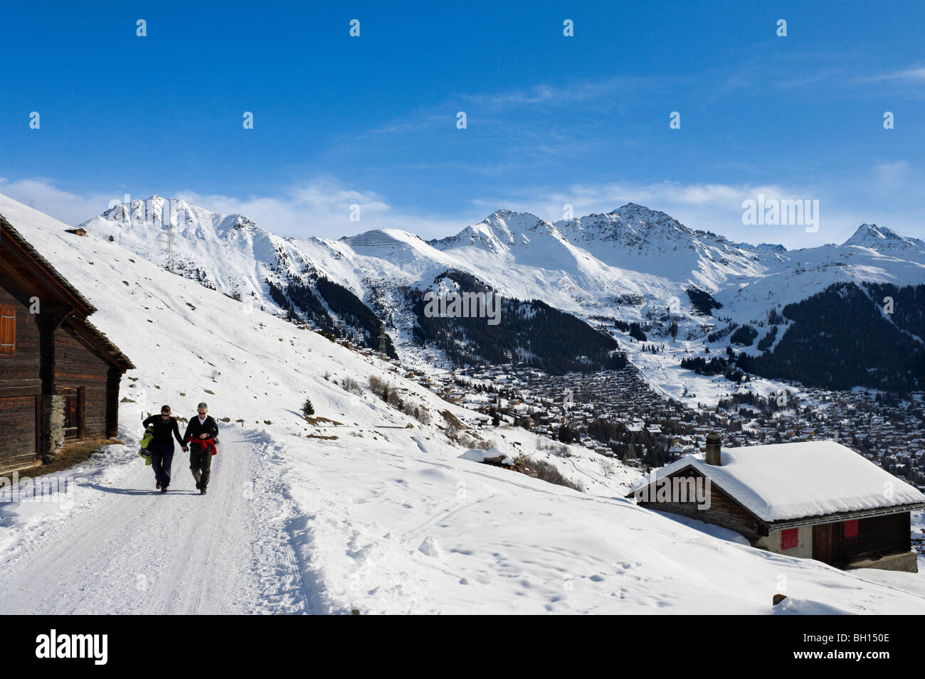 Couple walking on a path above the resort of Verbier, Valais, Switzerland Stock Photo
