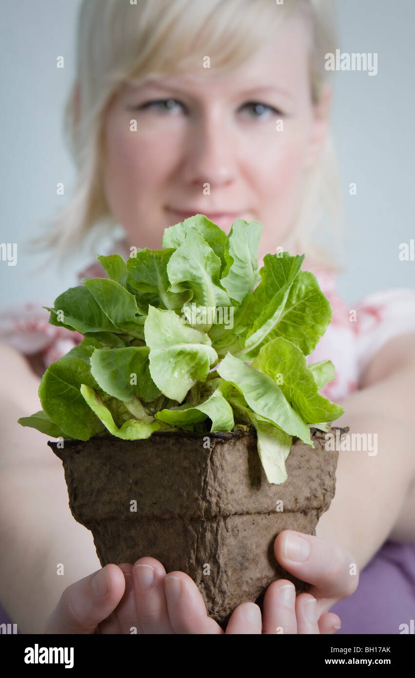 Young woman holding potted plant Stock Photo - Alamy