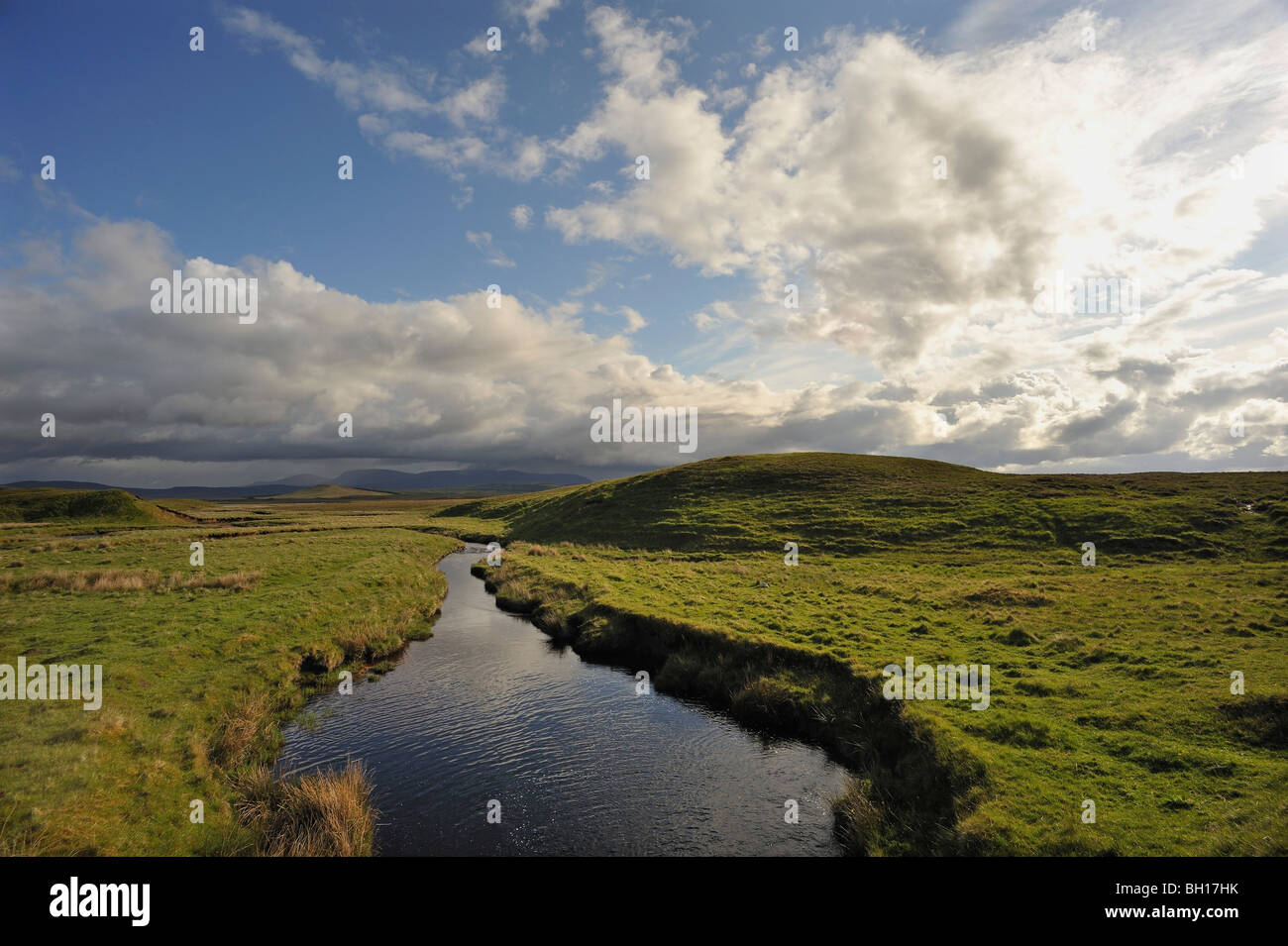 A quiet stream flows across empty moorland under a fine sky at Rimsdale in the flow-country of Sutherland/Caithness, Scotland Stock Photo