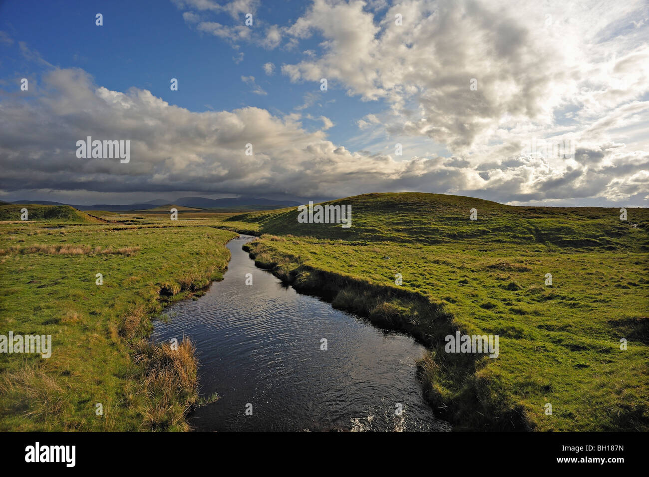 A quiet stream flows across empty moorland under a fine sky at Rimsdale in the flow-country of Sutherland/Caithness, Scotland Stock Photo