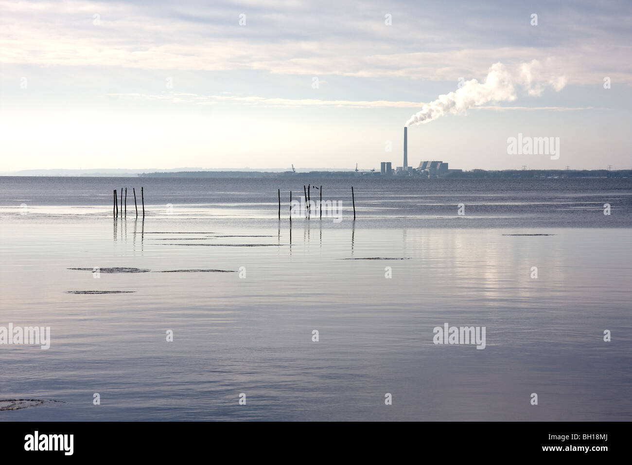 Calm, coastal sea, with a view to a factory Stock Photo