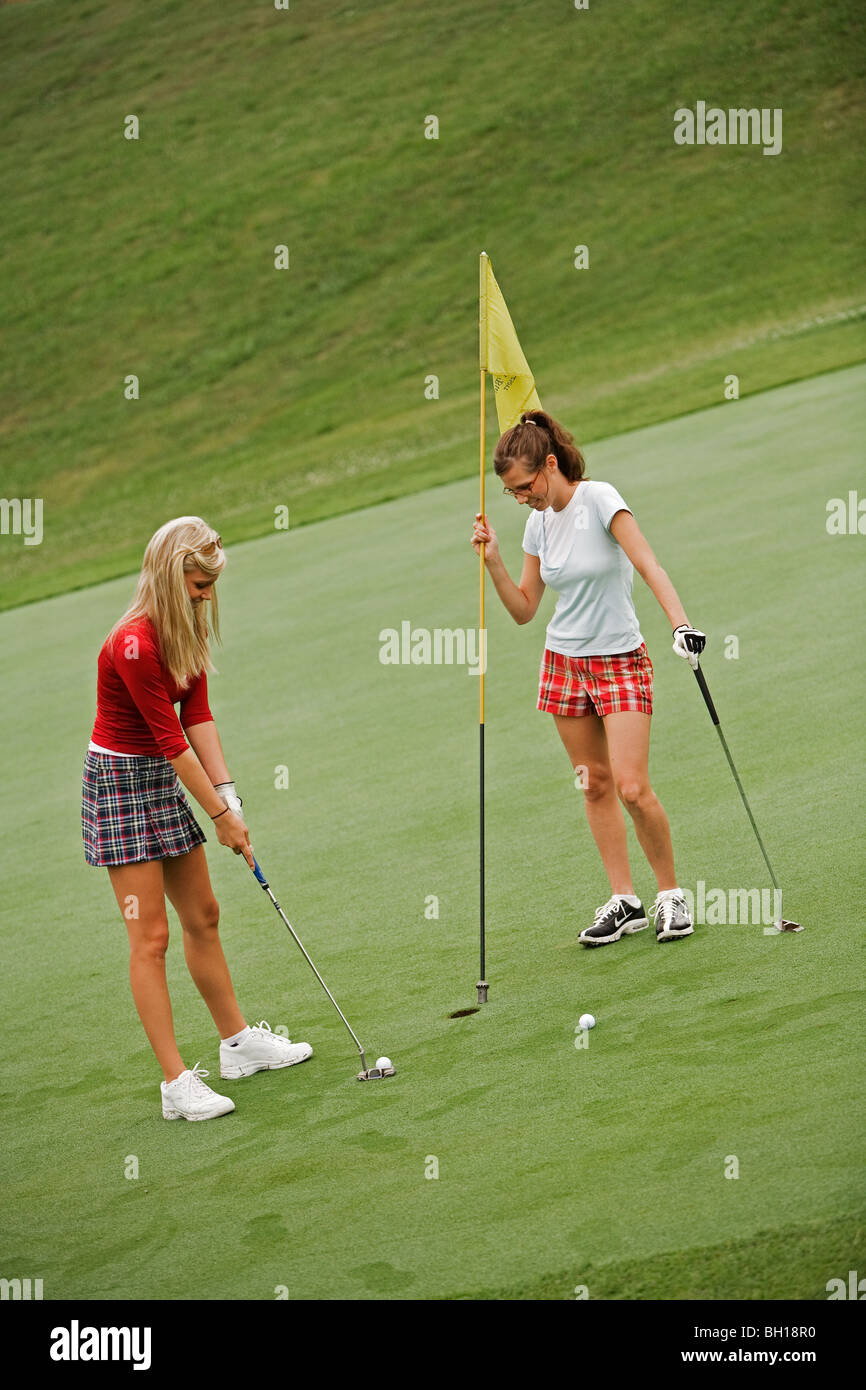 Women in their early 20s playing golf Stock Photo