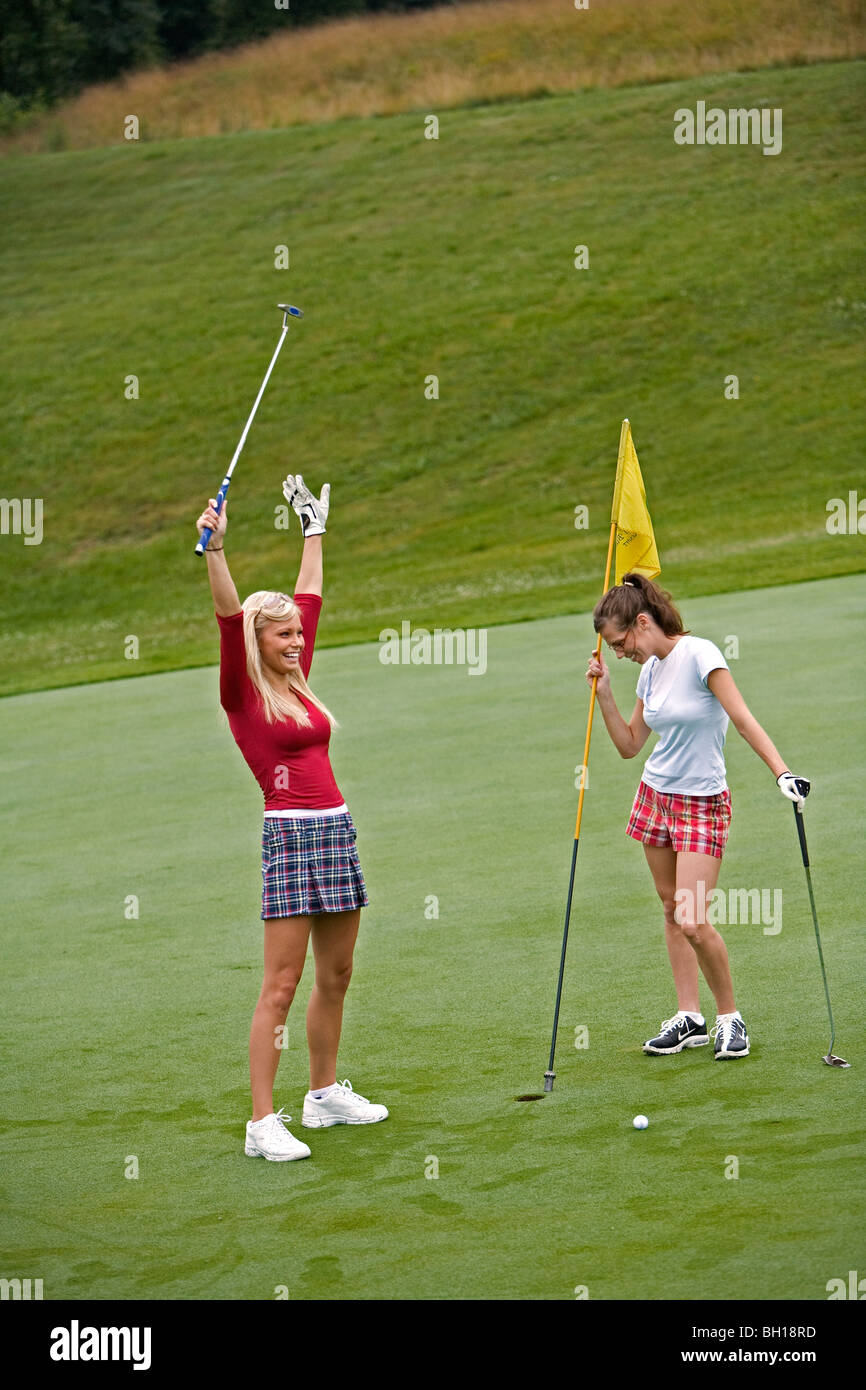 Women in their early 20s playing golf Stock Photo