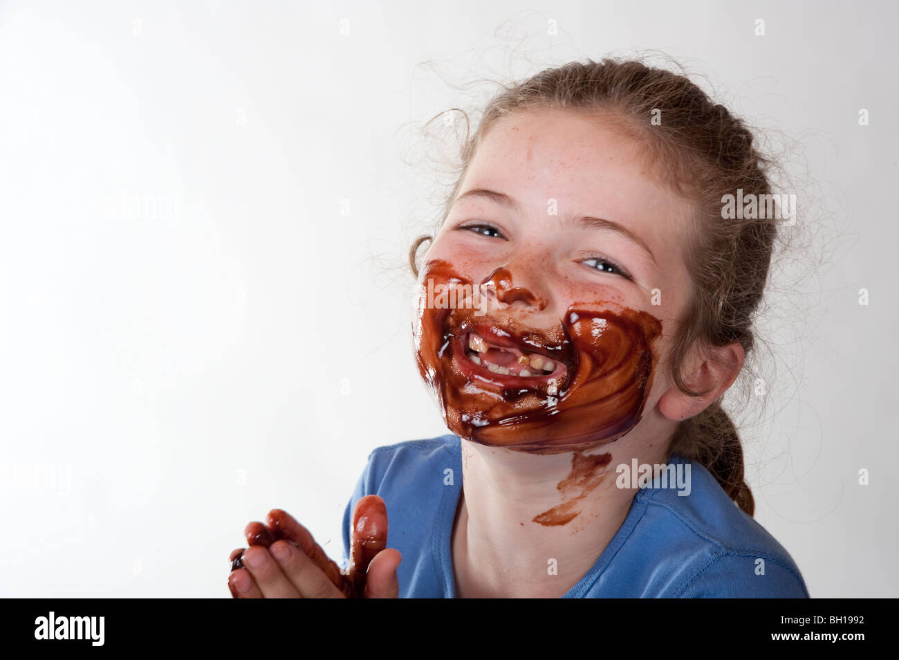 little girl smiling through chocolate covered face Stock Photo