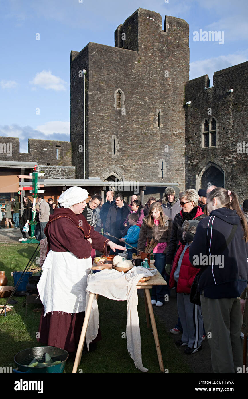 Woman preparing food in demonstration at Mediaeval Christmas market Caerphilly Castle Wales UK Stock Photo