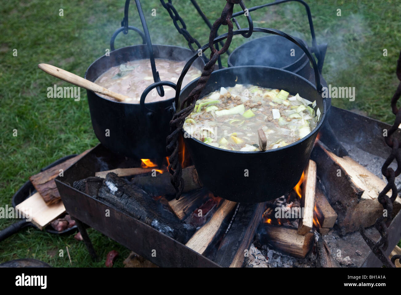 Cooking broth over wood fire Mediaeval Christmas market Caerphilly Wales UK Stock Photo