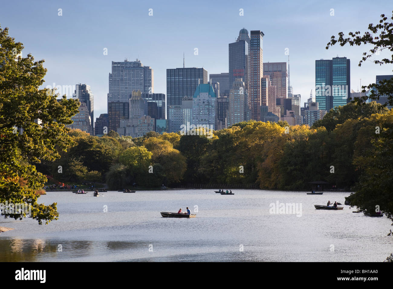 Fall view of boaters on The Lake in Central Park with Manhattan skyline. Stock Photo