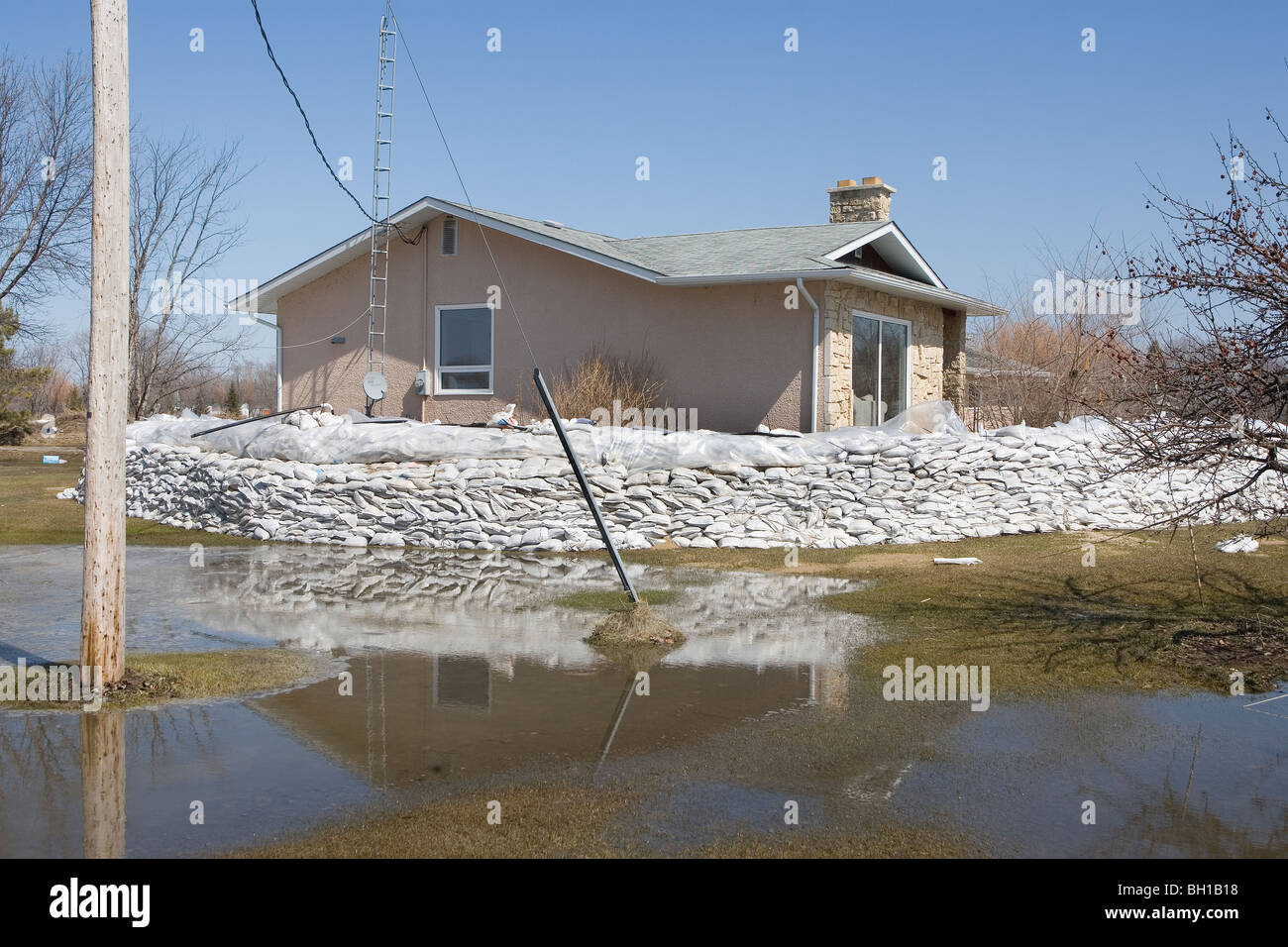 Dyke of sandbags around rural home to protect from Red River floodwaters, Manitoba, Canada Stock Photo