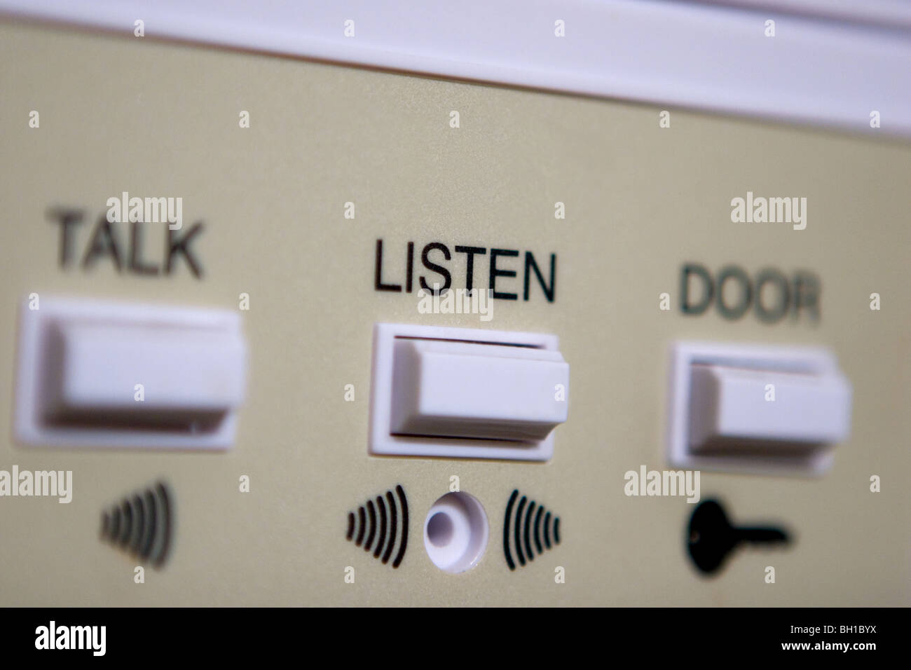 Closeup of a door buzzer system where "listen" is the prominent word