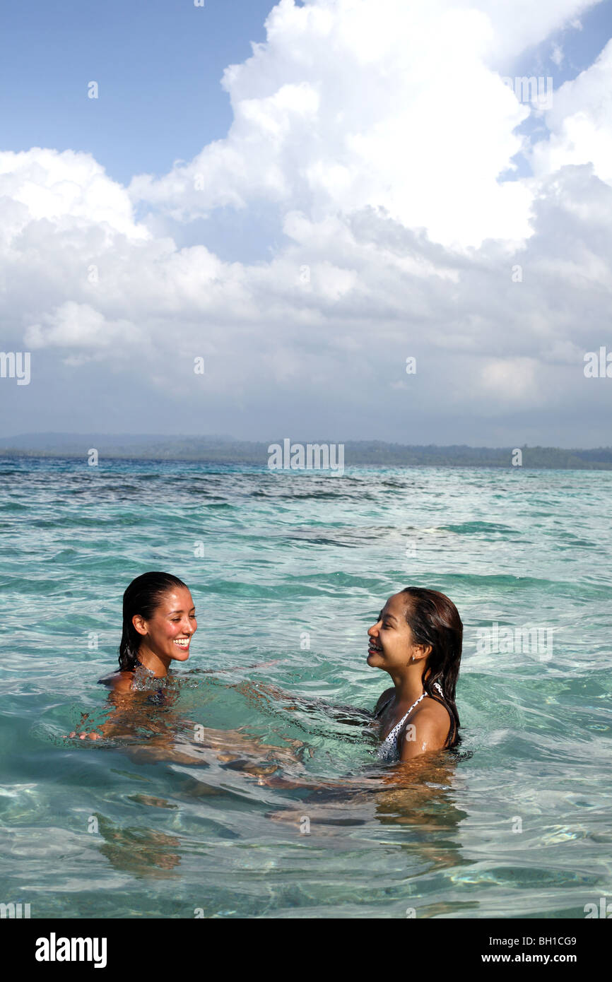 Two young woman enjoying the warm turquoise waters of Simakakang Island Stock Photo