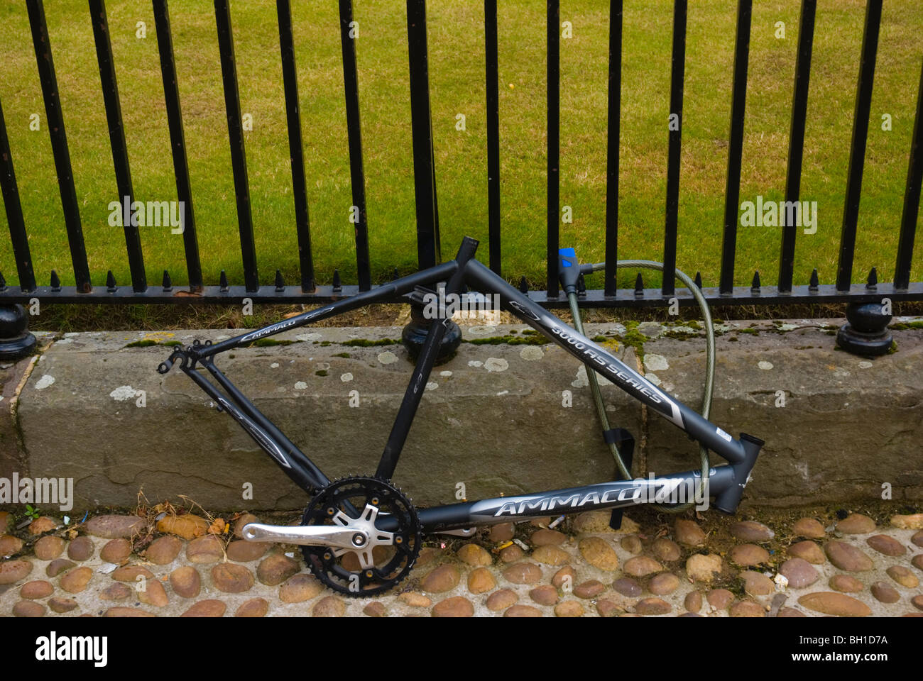 Locked bycycle stripped of wheels and seat Stock Photo