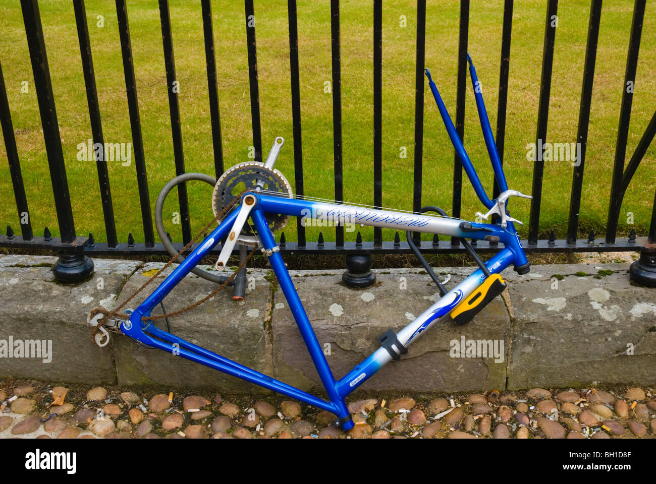 Locked bycycle stripped of wheels and seat Stock Photo
