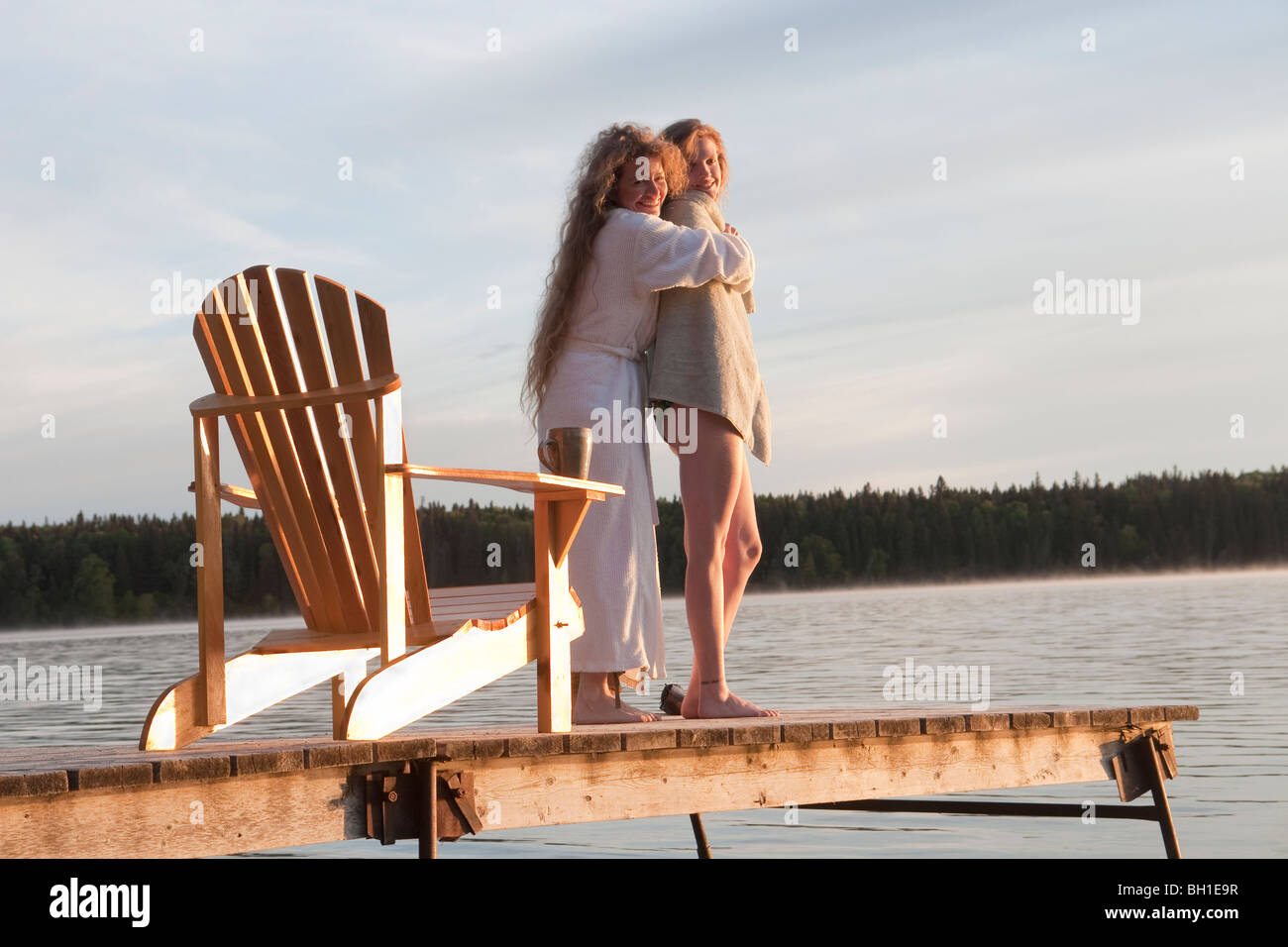 Two women embrace on dock, Clear Lake, Manitoba, Canada Stock Photo Alamy