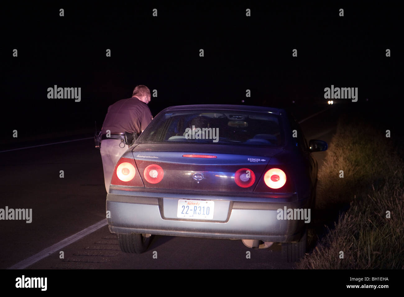 Traffic stop late at night on rural road. Deputy Sheriff. Driver was speeding. Note the full moon in the frame. Stock Photo