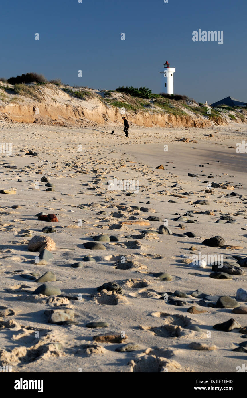 milnerton lighthouse and beach at dusk cape town south africa woman walking dog Stock Photo