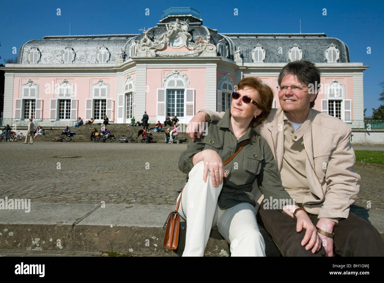 old couple sitting in front of the castle of Benrath, world heritage of UNESCO, sightseeing spot, local recreation area, Duessel Stock Photo