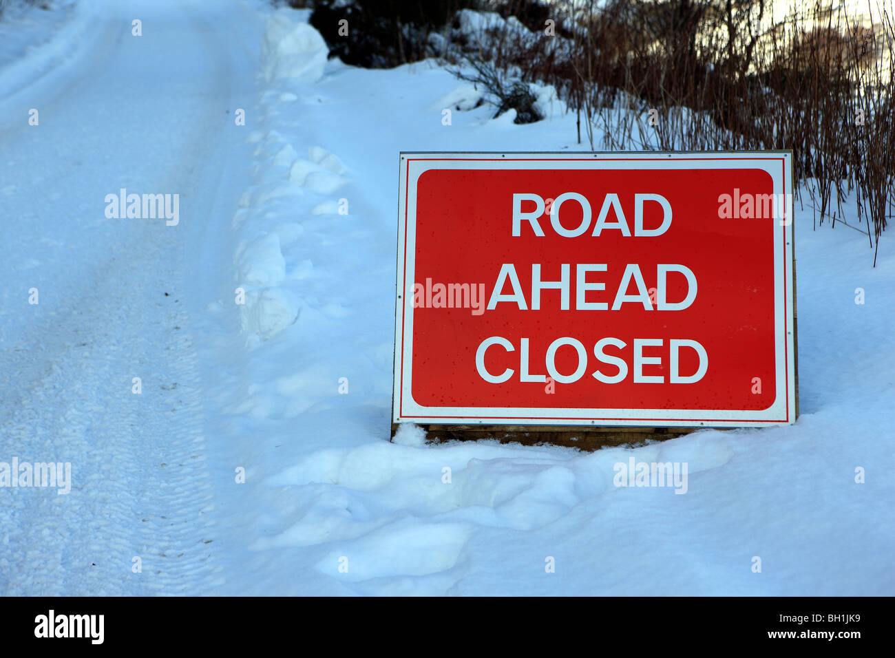 Road closed sign on a snow covered road Stock Photo