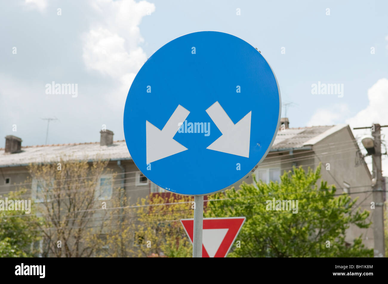 blue circular pass either side sign with white arrows Stock Photo