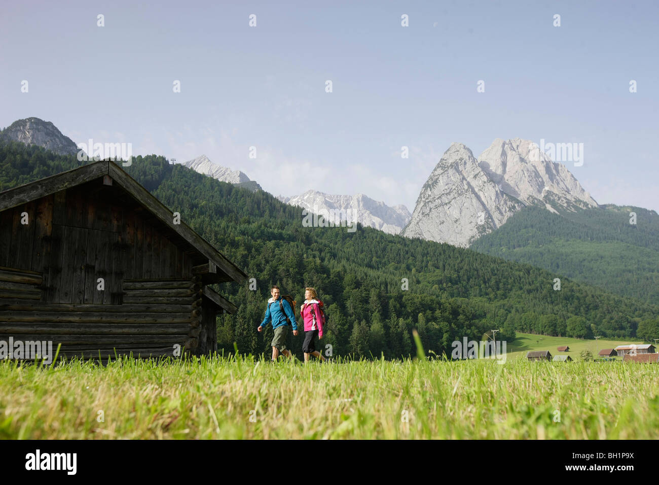 Hikers near alpine lodge, Werdenfelser Land, Bavaria, Germany Stock Photo