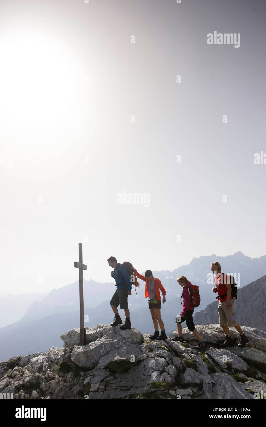 Hikers near summit cross, Wetterstein range, Bavaria, Germany Stock Photo