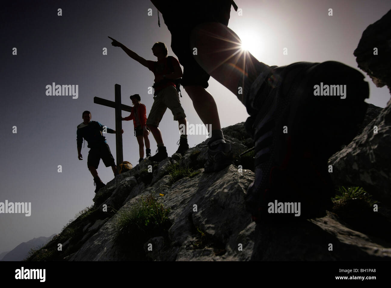 Hikers arriving summit cross, Wetterstein range, Bavaria, Germany Stock Photo