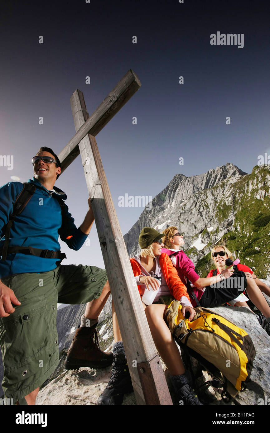 Group hikers near a summit cross, Wetterstein range, Bavaria, Germany Stock Photo